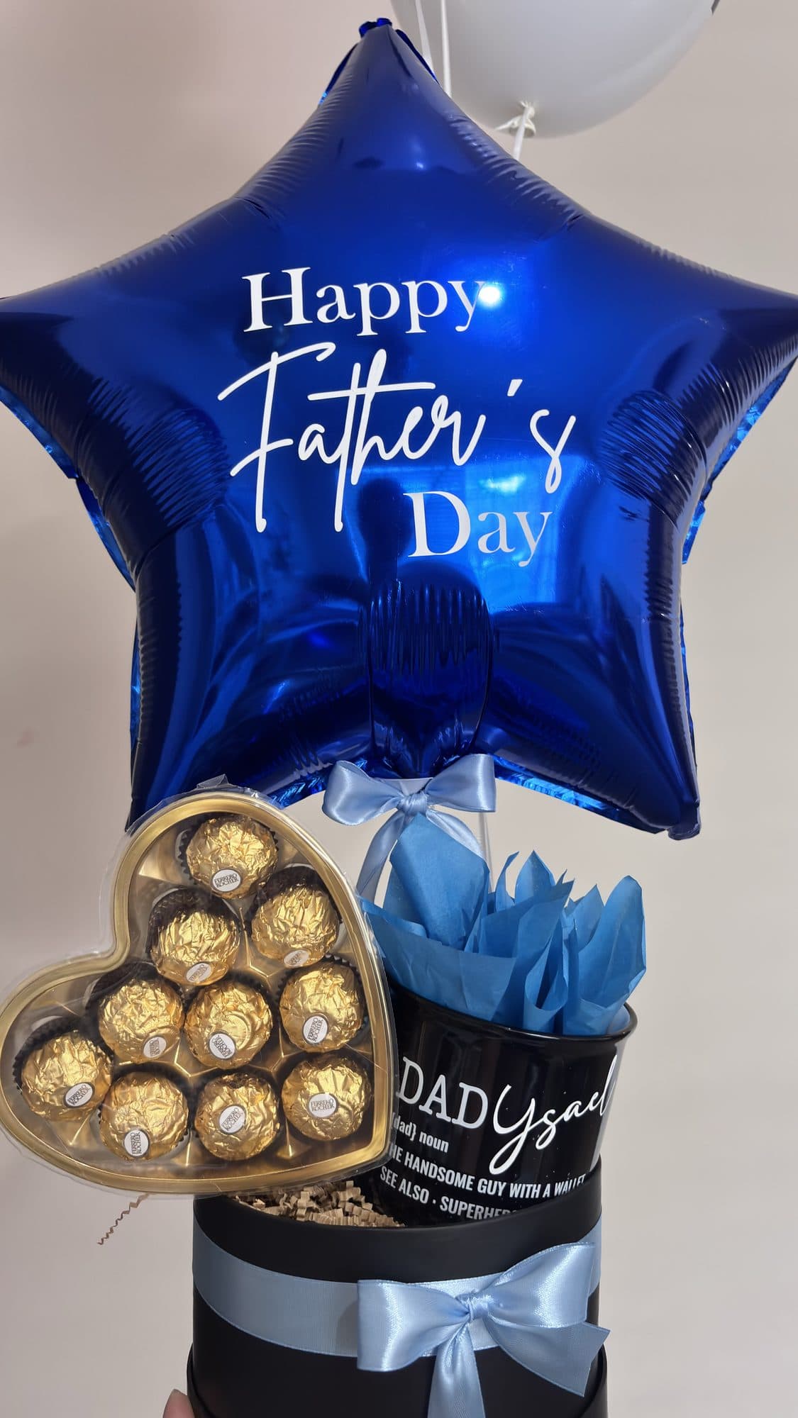 Close-up of a Happy Father's Day star balloon with a chocolate gift box balloon bouquet