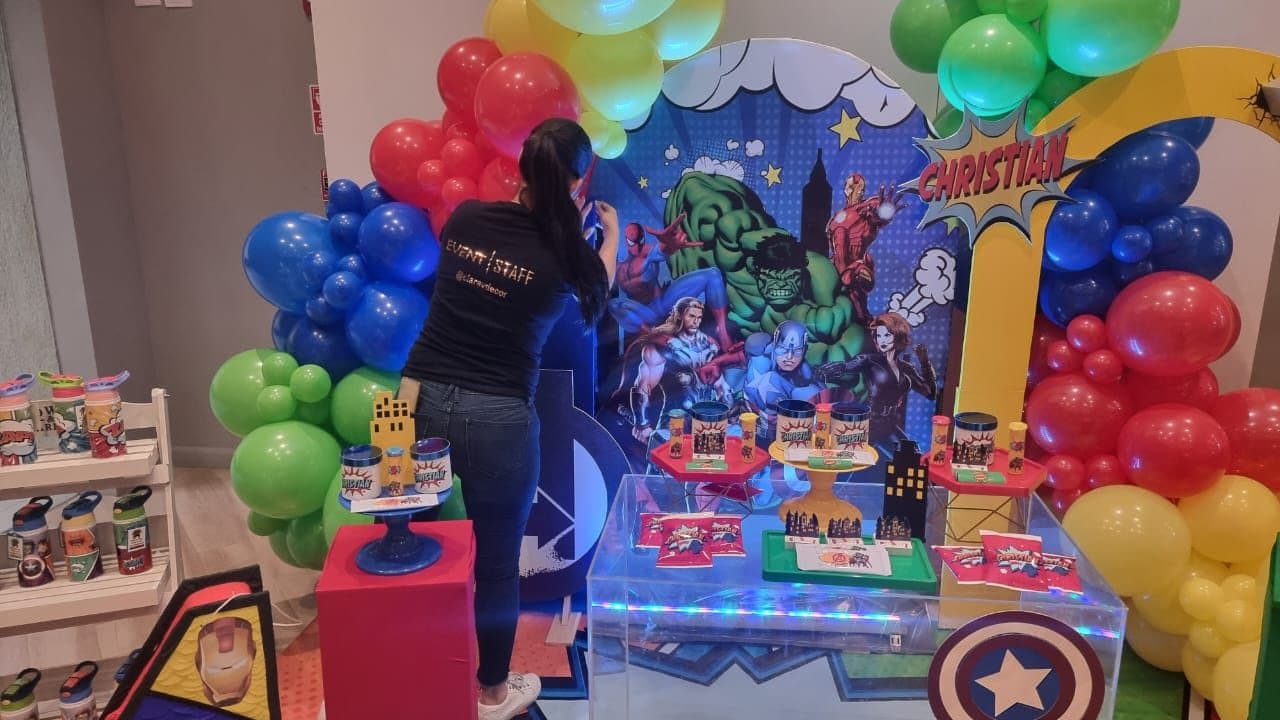 Colorful Avengers superhero themed balloon column and dessert table with a comic backdrop