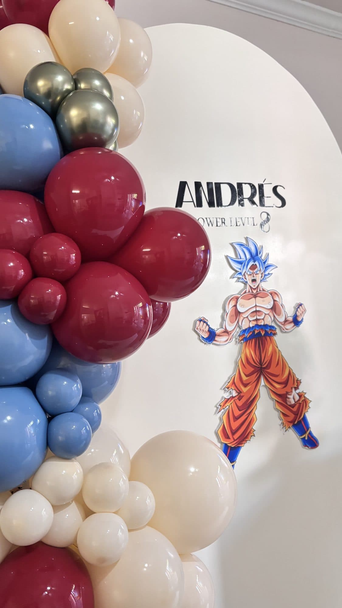 Close-up of the red, blue and cream Dragon Ball Z themed balloon backdrop with character cutouts