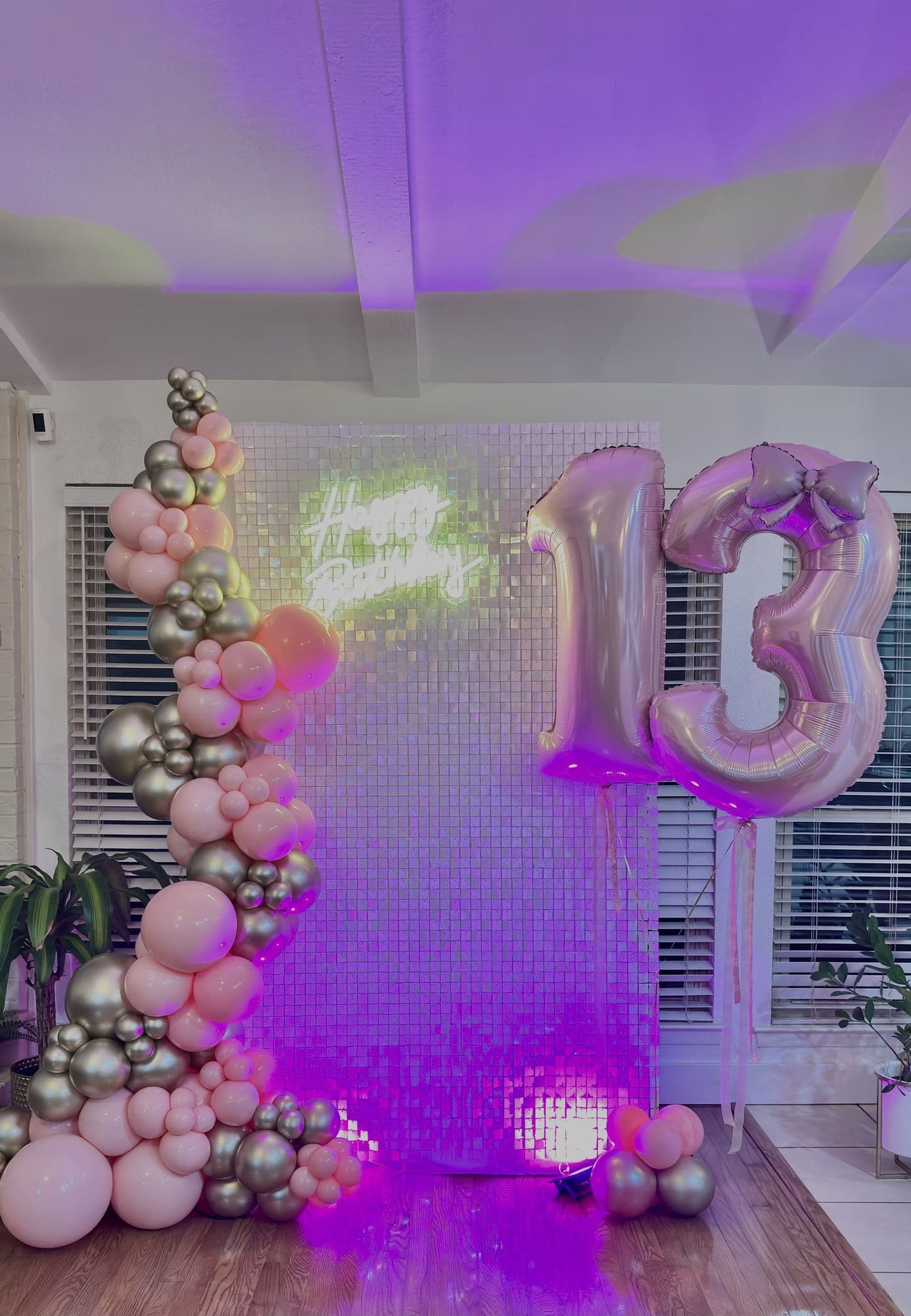 Pink and silver balloon garland on a shimmer wall backdrop with 13 number balloons for a teen birthday