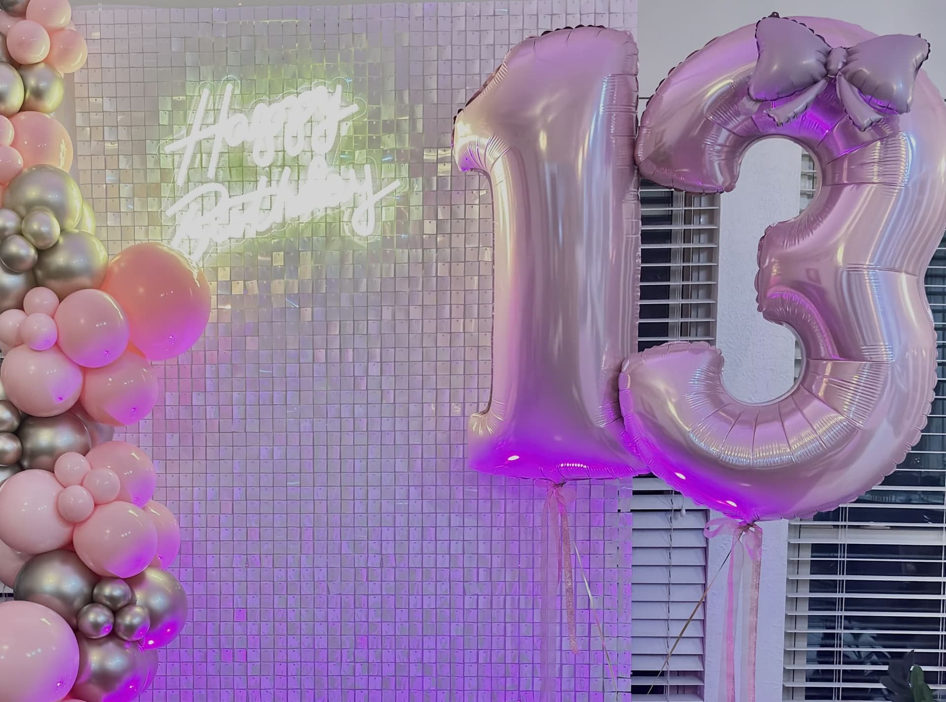 Close-up of the pink and silver balloon garland and 13 number balloons on a shimmer wall