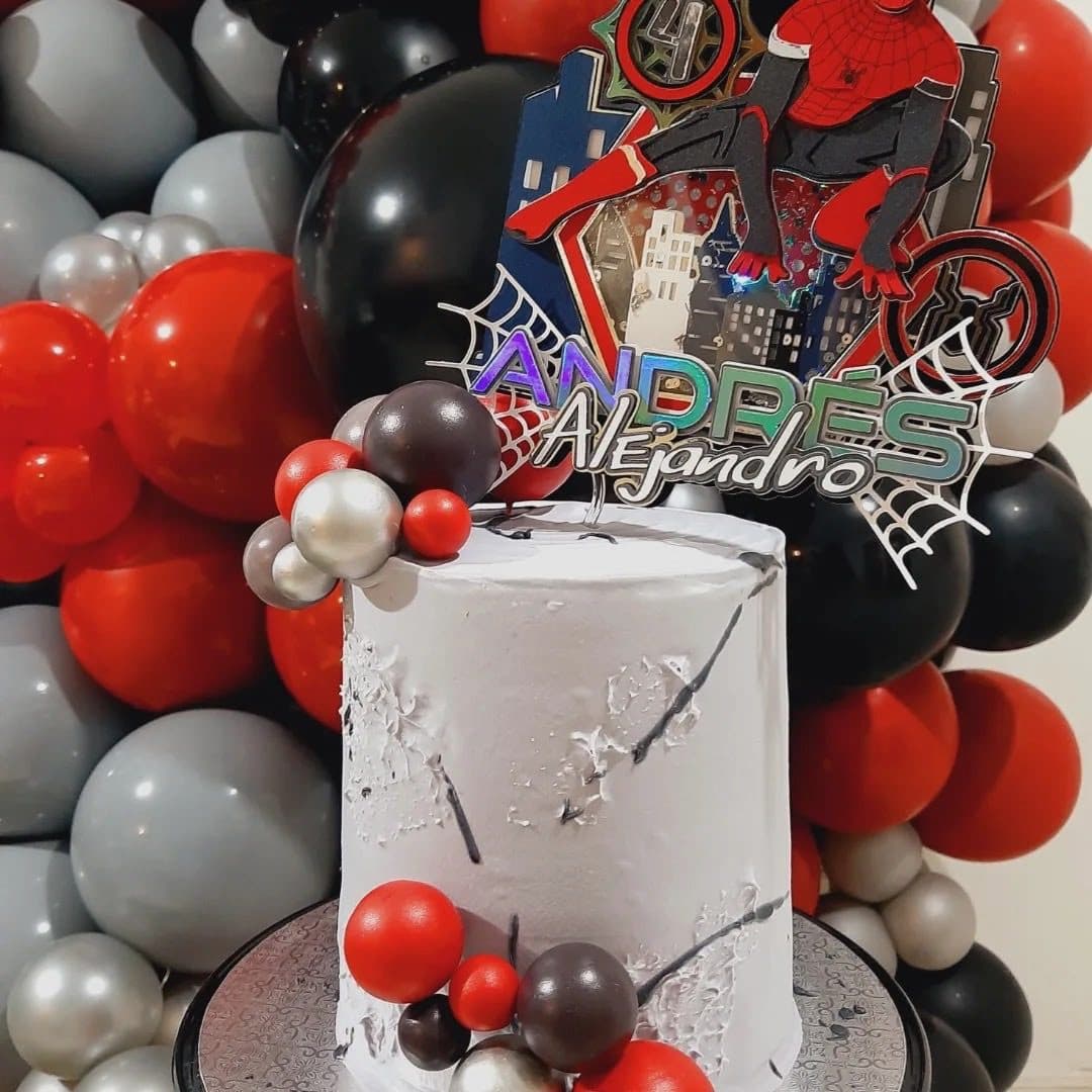 Red, black and silver Spider-Man themed birthday cake display with a comic-style name sign