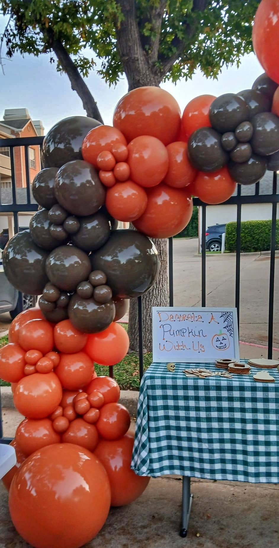 Wide view of an orange, brown and black fall balloon garland framing a front door entrance